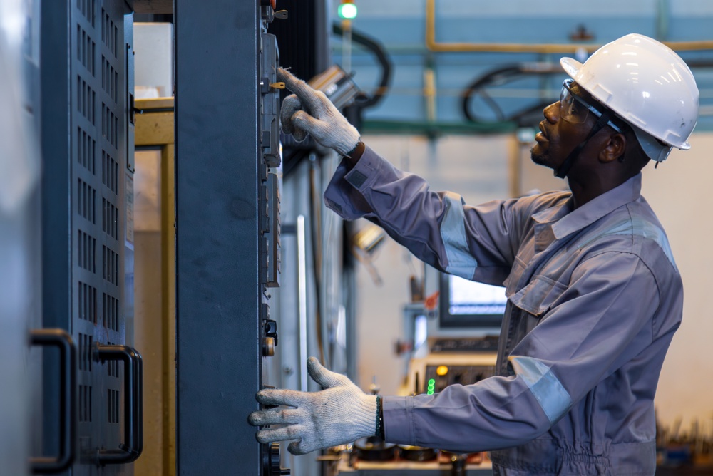 Industrial electrician working on machinery control panel